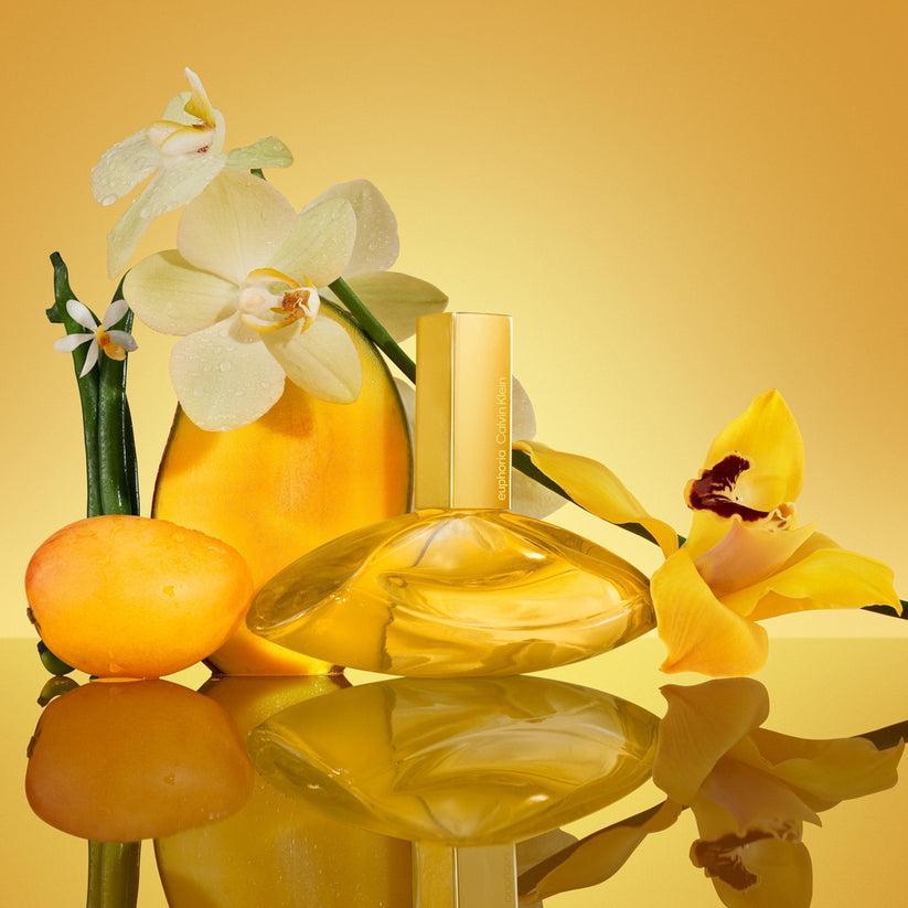 PARFUM INTENSE EUPHORIA SOLAR 100ML Flacone in ambiente con fiori e agrumi